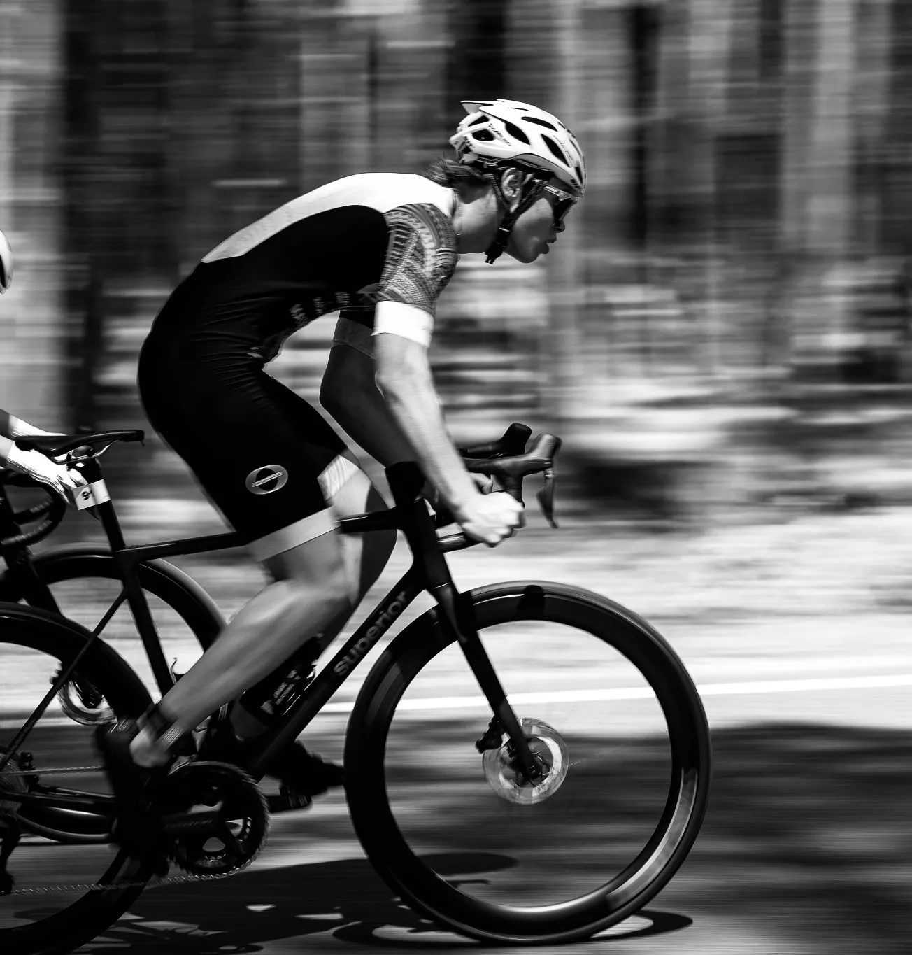 Oliver on the bike seen from the side, panning shot. Black and white.